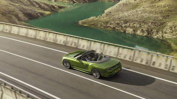 Green Bentley Continental GT Speed Convertible driving on an open road