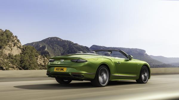 Green Bentley Continental GT Speed Convertible driving on an open road