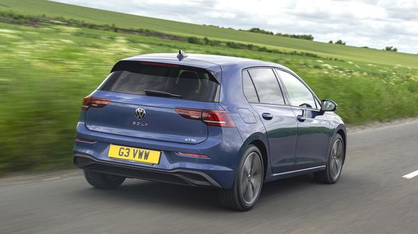 Blue 2024 Volkswagen Golf rear driving on road